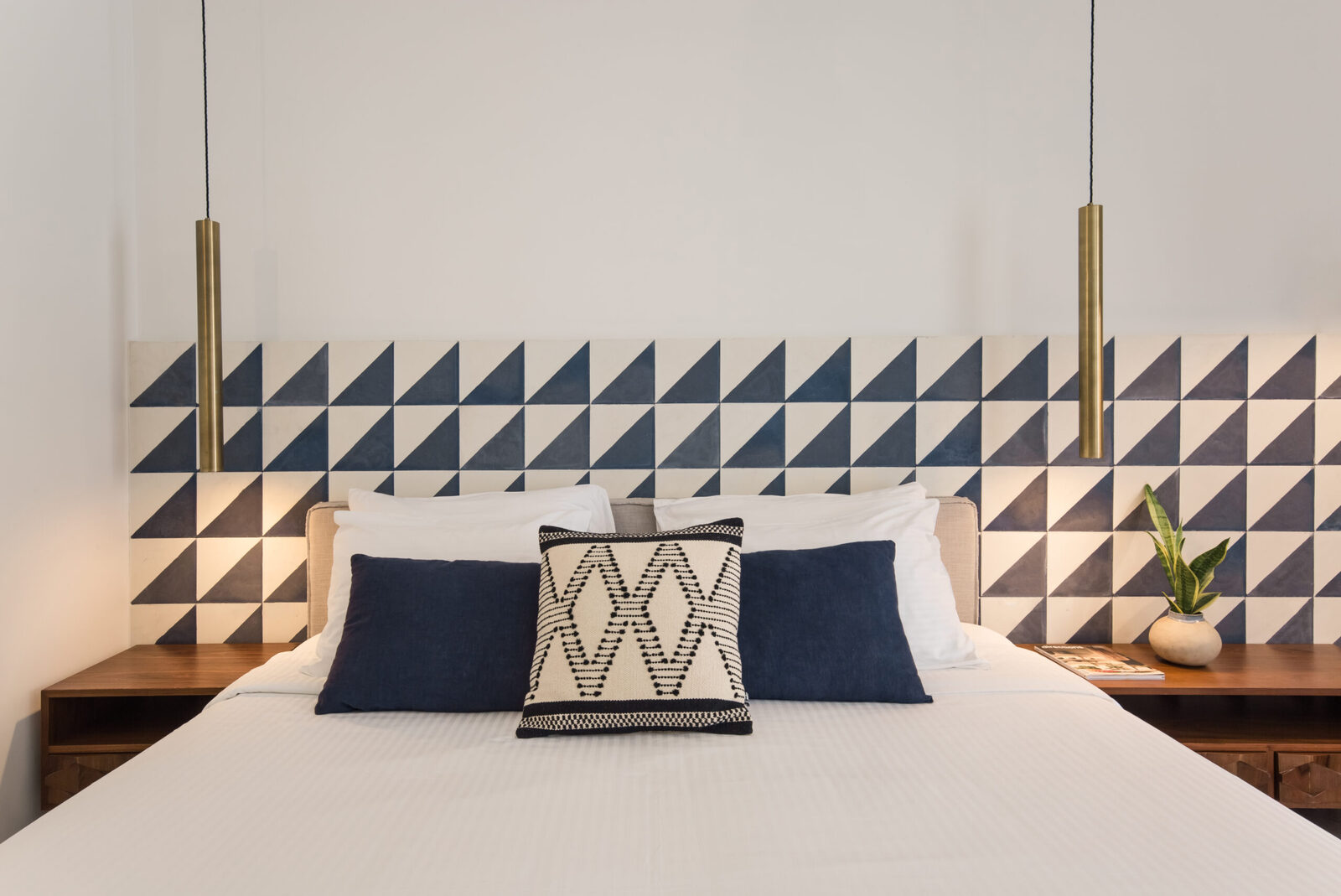 A boutique hotel room with chestnut wood furniture and a blue geometric mural at Phaea Cretan Malia